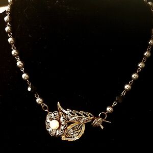 Vintage necklace with a large flower pin connected on it.